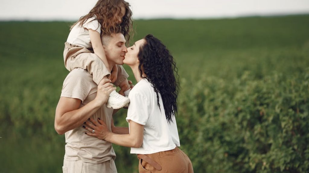 A heartwarming family moment captured in a field, highlighting love and togetherness.